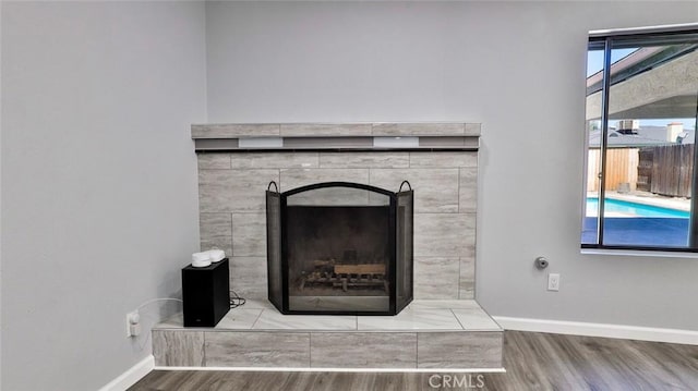 room details featuring wood-type flooring and a tiled fireplace