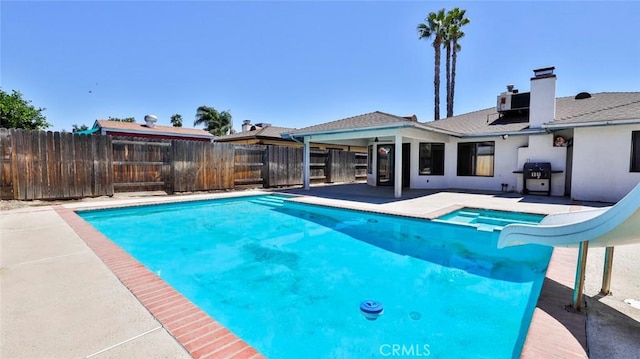 view of swimming pool featuring a patio, a water slide, a grill, and central AC unit