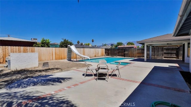 view of swimming pool featuring a patio and a water slide