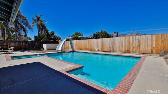 view of swimming pool with a patio area and a water slide