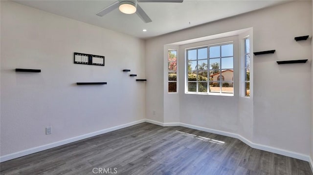 spare room with dark hardwood / wood-style floors and ceiling fan