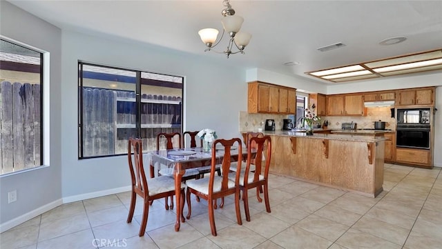 dining area featuring light tile patterned flooring, plenty of natural light, and a chandelier