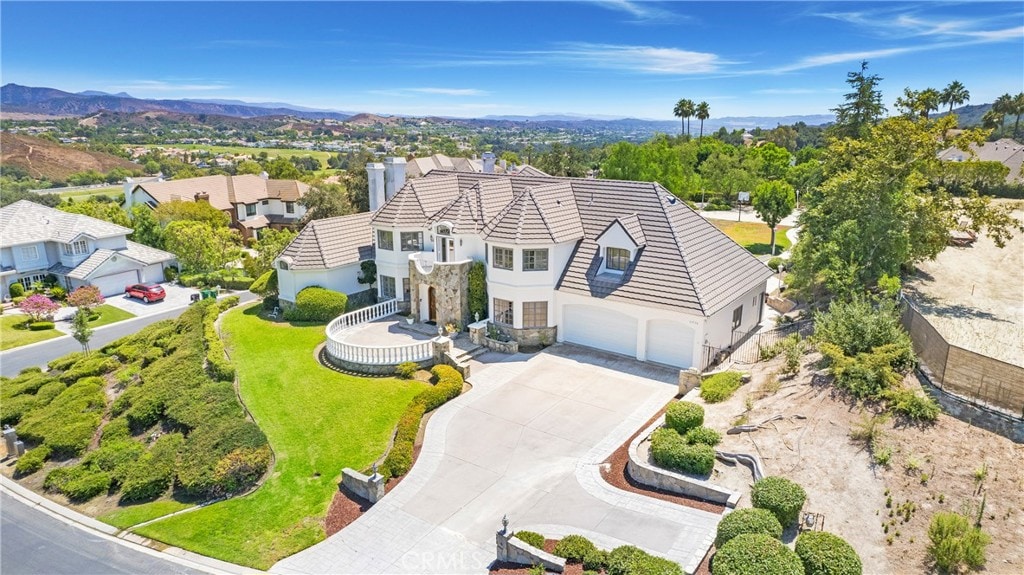 view of front facade featuring a front yard, a mountain view, and a garage