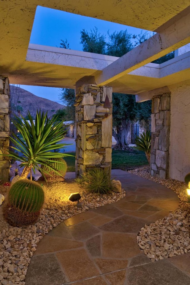 patio terrace at dusk featuring a mountain view