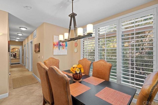 tiled dining room with a chandelier, visible vents, and baseboards