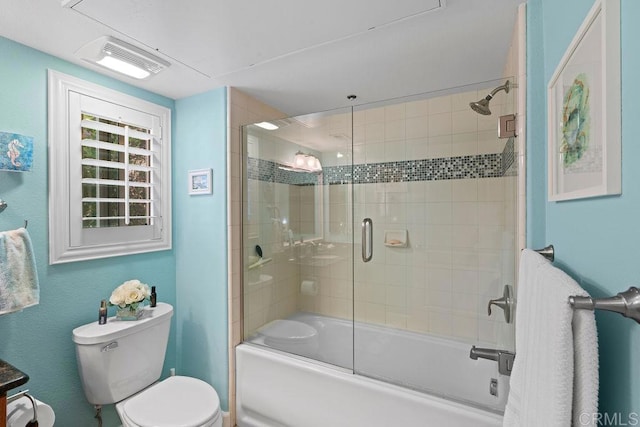 full bathroom featuring toilet, visible vents, and shower / bath combination with glass door