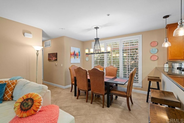 dining space featuring light tile patterned floors, visible vents, baseboards, and a notable chandelier