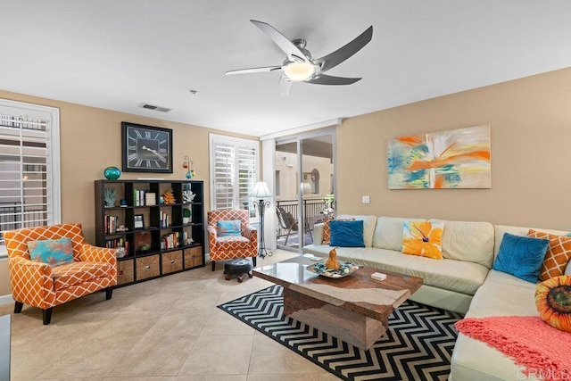 living area featuring light tile patterned floors, visible vents, and a ceiling fan