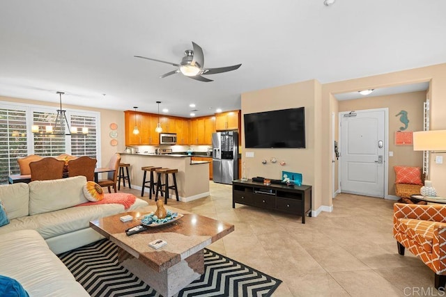 living room featuring recessed lighting, light tile patterned floors, ceiling fan with notable chandelier, and baseboards