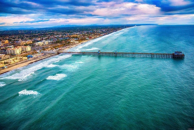 aerial view at dusk with a beach view and a water view