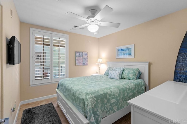 bedroom featuring multiple windows, a ceiling fan, and baseboards