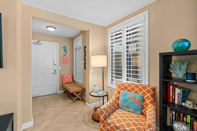 living area featuring tile patterned floors and baseboards