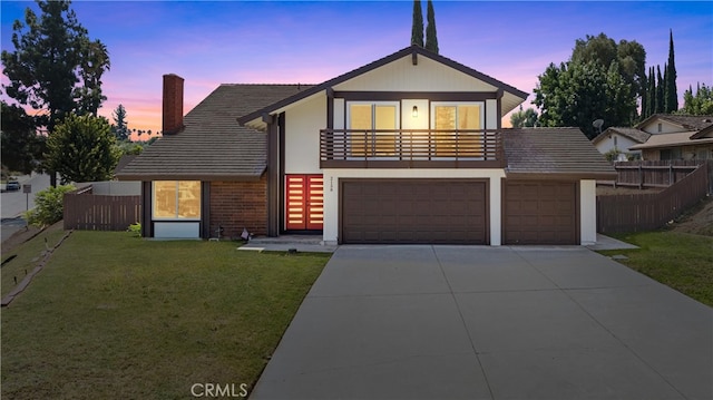 view of front property featuring a yard, a garage, and a balcony