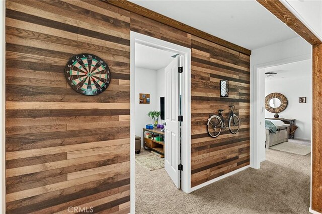 corridor with wood walls and carpet floors