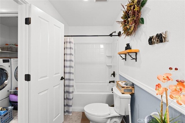 bathroom with shower / bath combo with shower curtain, lofted ceiling, toilet, and washer / dryer