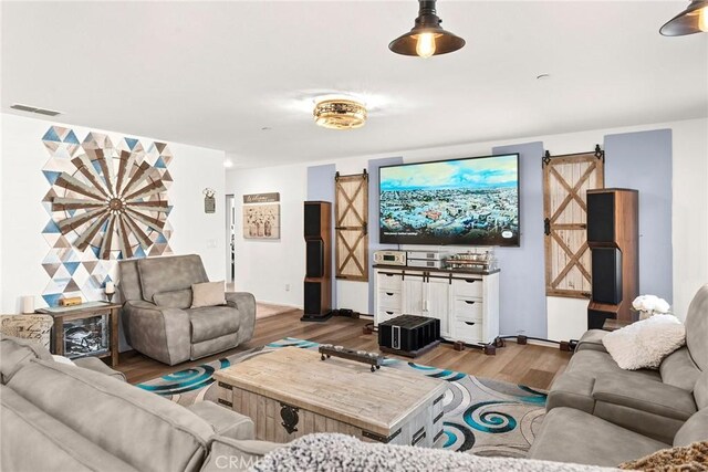 living room featuring a barn door and hardwood / wood-style flooring