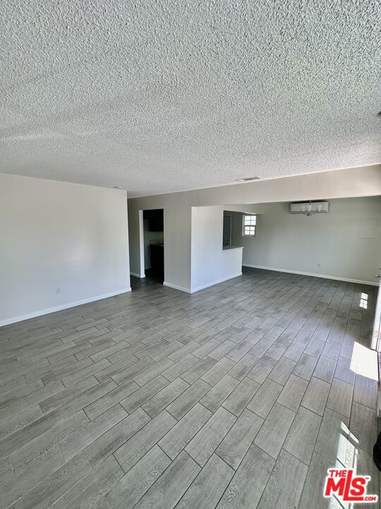 empty room with light hardwood / wood-style floors and a textured ceiling