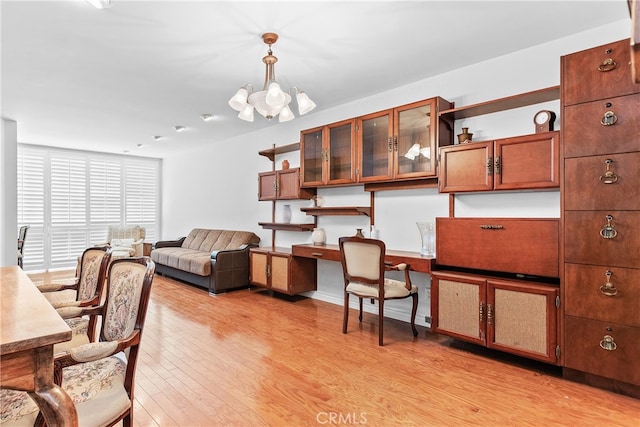 home office featuring a notable chandelier and light wood-type flooring