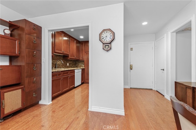 kitchen featuring decorative backsplash, white dishwasher, light hardwood / wood-style floors, and sink