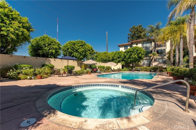 view of swimming pool with a community hot tub and a patio area