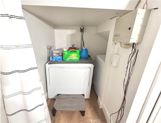 laundry area featuring light hardwood / wood-style flooring and washing machine and dryer