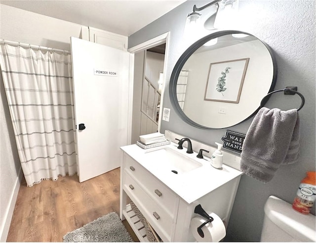 bathroom featuring toilet, vanity, and hardwood / wood-style floors