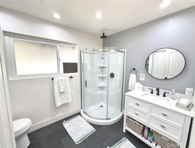 bathroom with tile patterned floors, a shower with door, vanity, and toilet