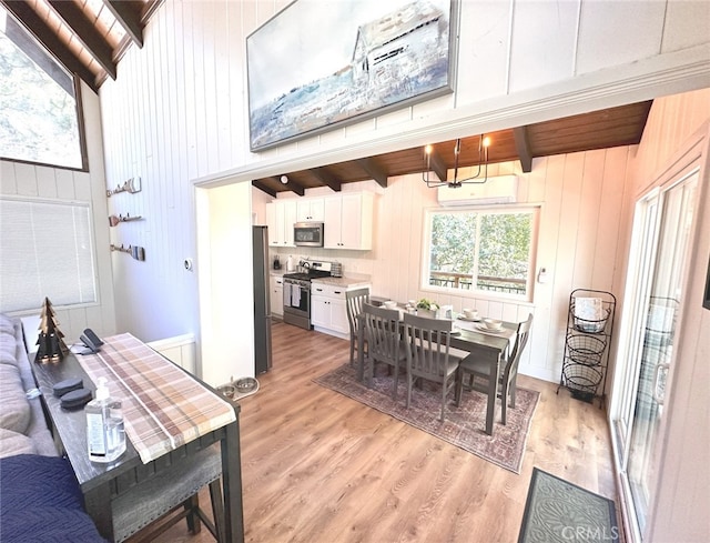 dining space with beamed ceiling, light hardwood / wood-style flooring, wooden walls, high vaulted ceiling, and an AC wall unit