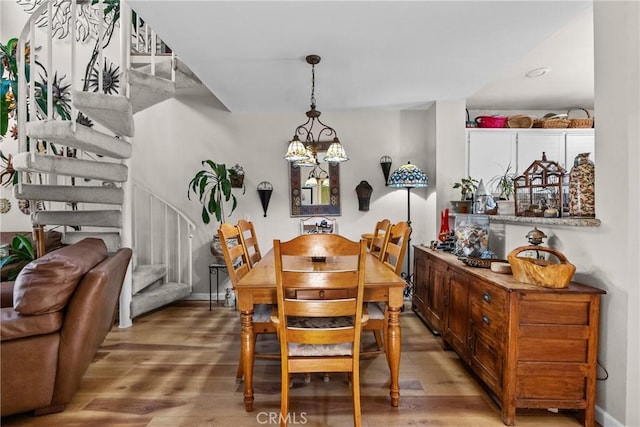 dining area with hardwood / wood-style floors and a notable chandelier