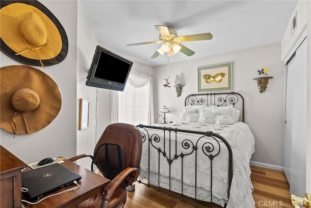 bedroom with ceiling fan, a closet, and hardwood / wood-style flooring