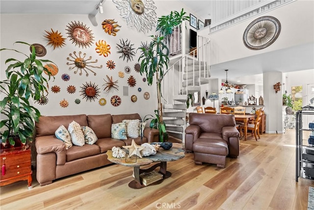 living room with hardwood / wood-style flooring, high vaulted ceiling, and track lighting