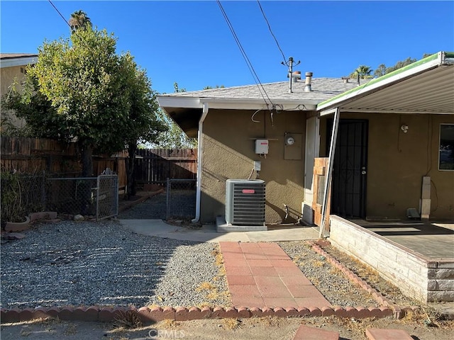 rear view of property with cooling unit and a patio area