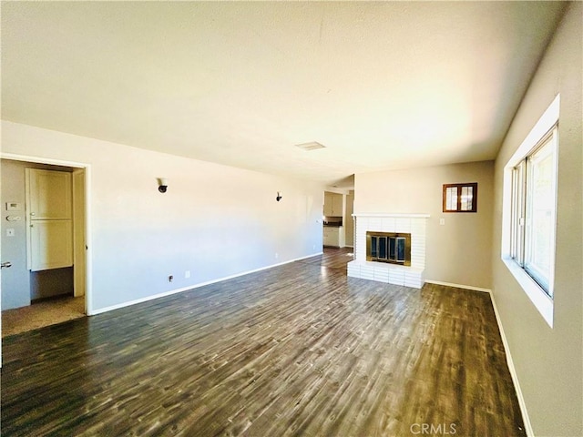 unfurnished living room with a fireplace and dark wood-type flooring