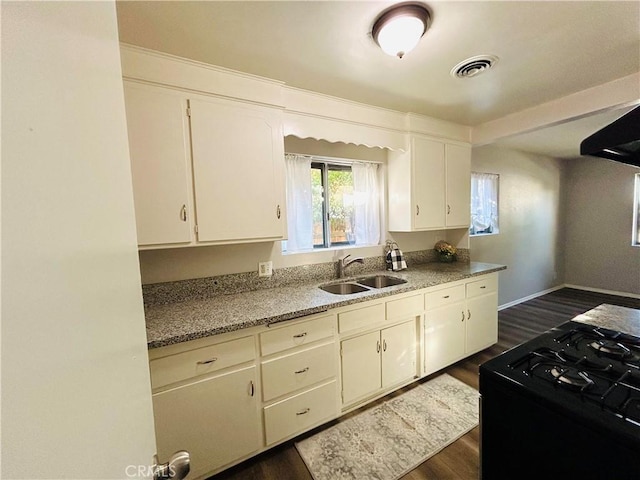 kitchen featuring white cabinetry, sink, black range oven, dark wood-type flooring, and stone countertops