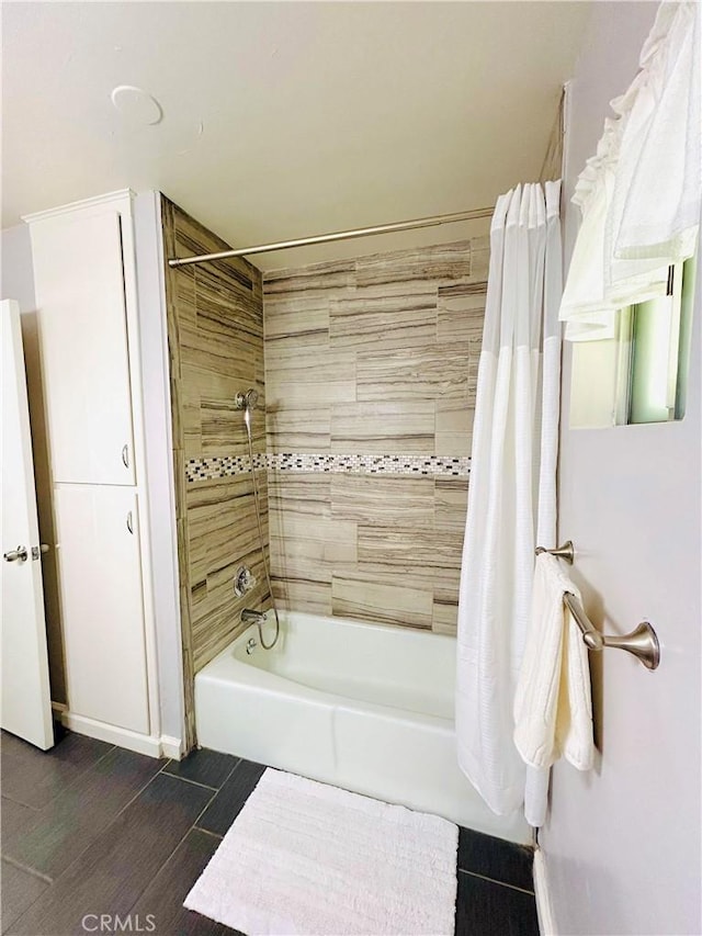 bathroom with hardwood / wood-style floors and shower / bathtub combination with curtain