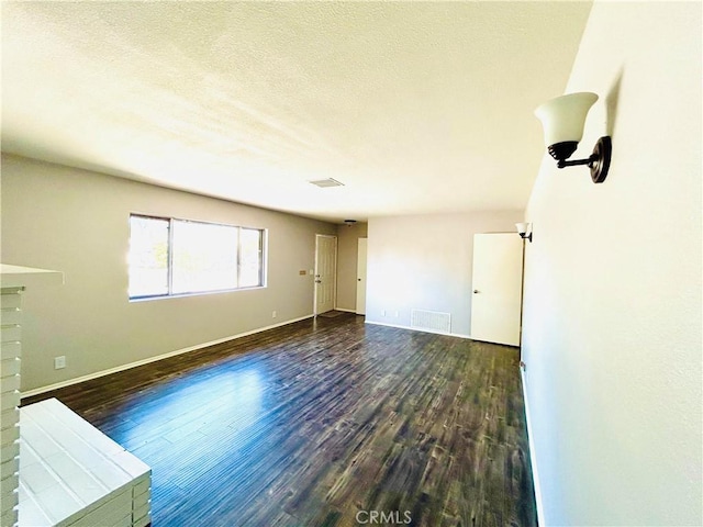 interior space with a textured ceiling and dark wood-type flooring