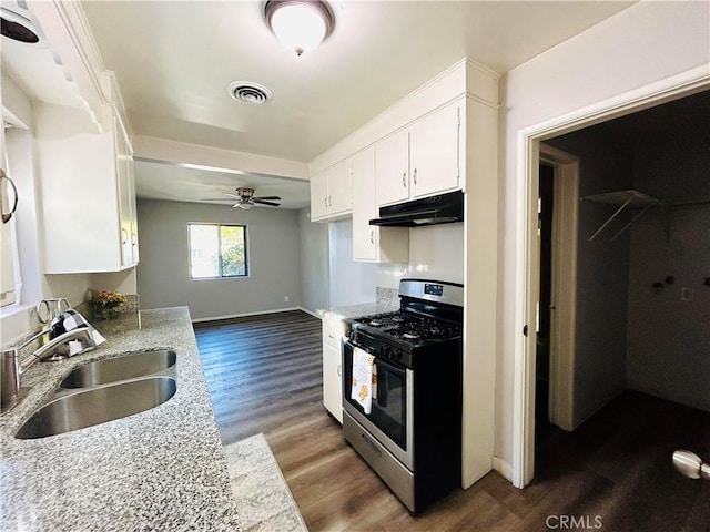 kitchen with stainless steel gas range oven, dark hardwood / wood-style flooring, white cabinetry, and sink