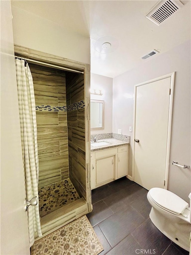 bathroom featuring tile patterned flooring, a shower with curtain, toilet, and vanity