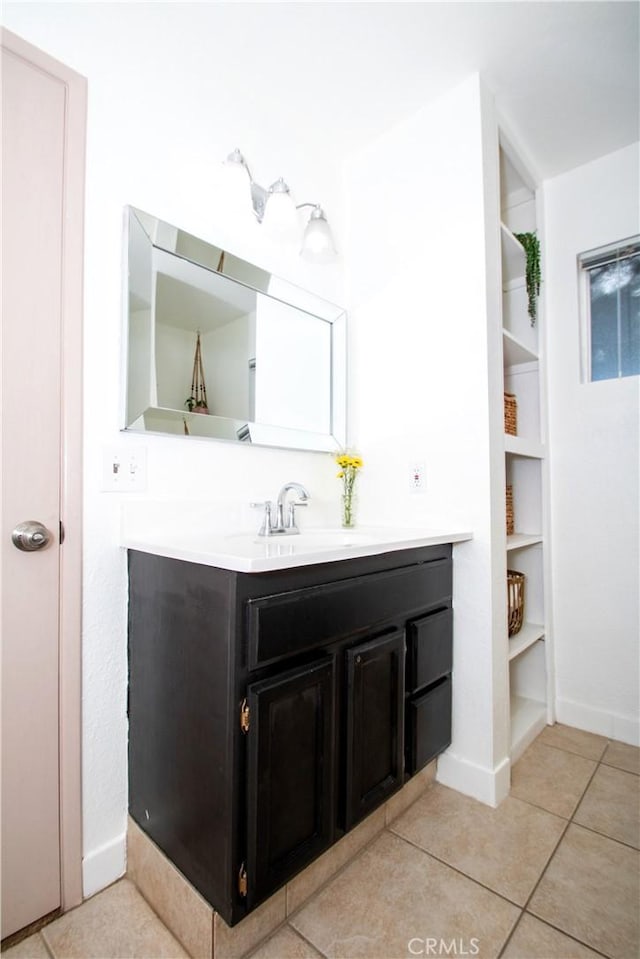 bathroom with vanity, baseboards, and tile patterned floors
