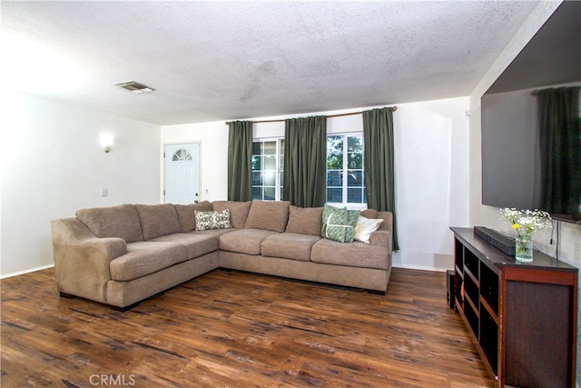 living room featuring a textured ceiling and dark wood-type flooring