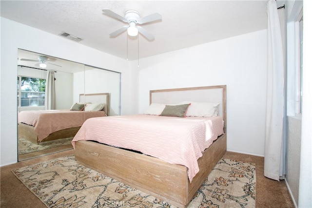 bedroom with light carpet, ceiling fan, and a closet