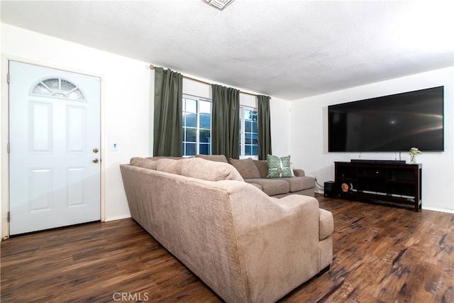 living room with a textured ceiling and dark wood-type flooring