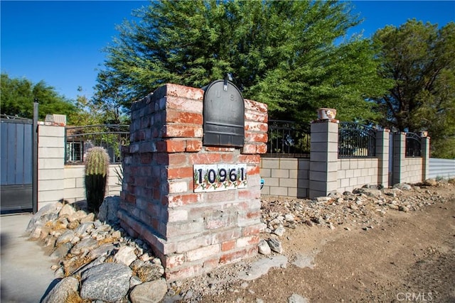 community sign with fence and a gate