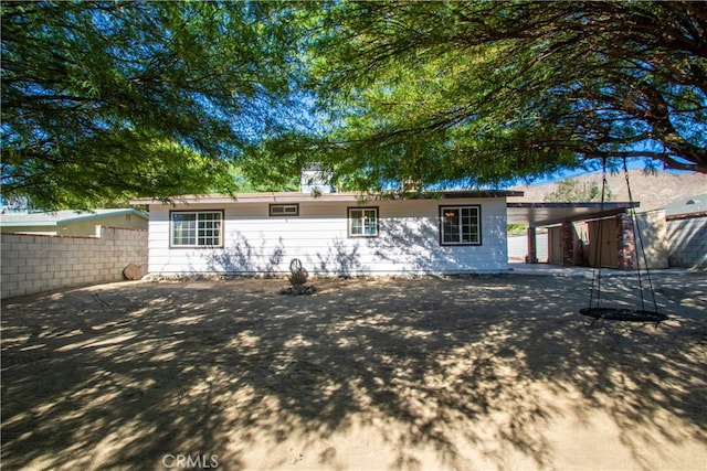 back of house featuring a carport