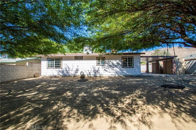 rear view of house featuring fence