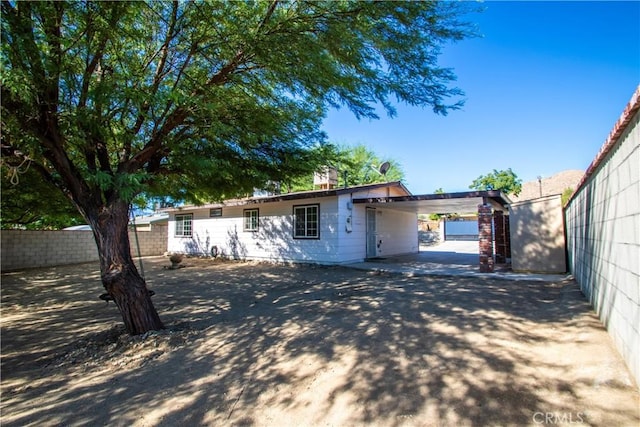 back of property featuring fence and a carport