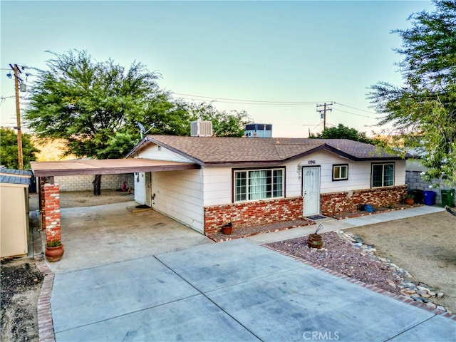 ranch-style house featuring central AC and a carport