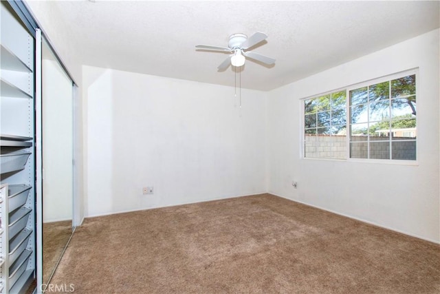 spare room featuring a ceiling fan and carpet