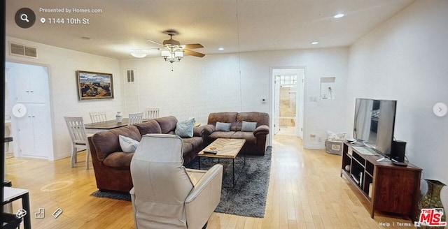 living room featuring light hardwood / wood-style flooring and ceiling fan