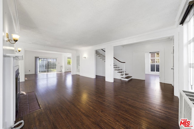 unfurnished living room with dark hardwood / wood-style floors, ornamental molding, and a textured ceiling